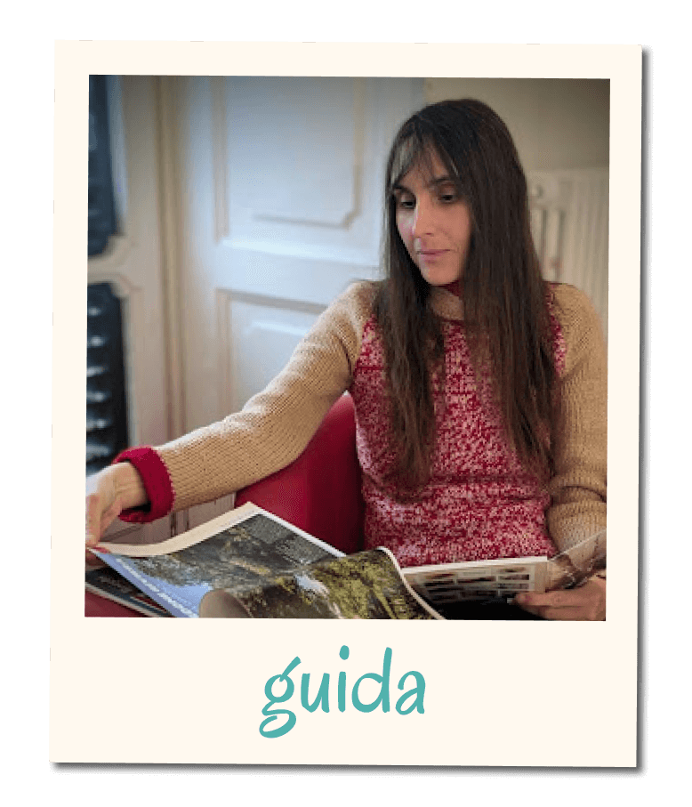 Card di una guida con fotografia in stile polaroid di Flavia seduta in un ambiente interno mentre sfoglia una rivista, con la scritta ‘guida’ nella cornice inferiore