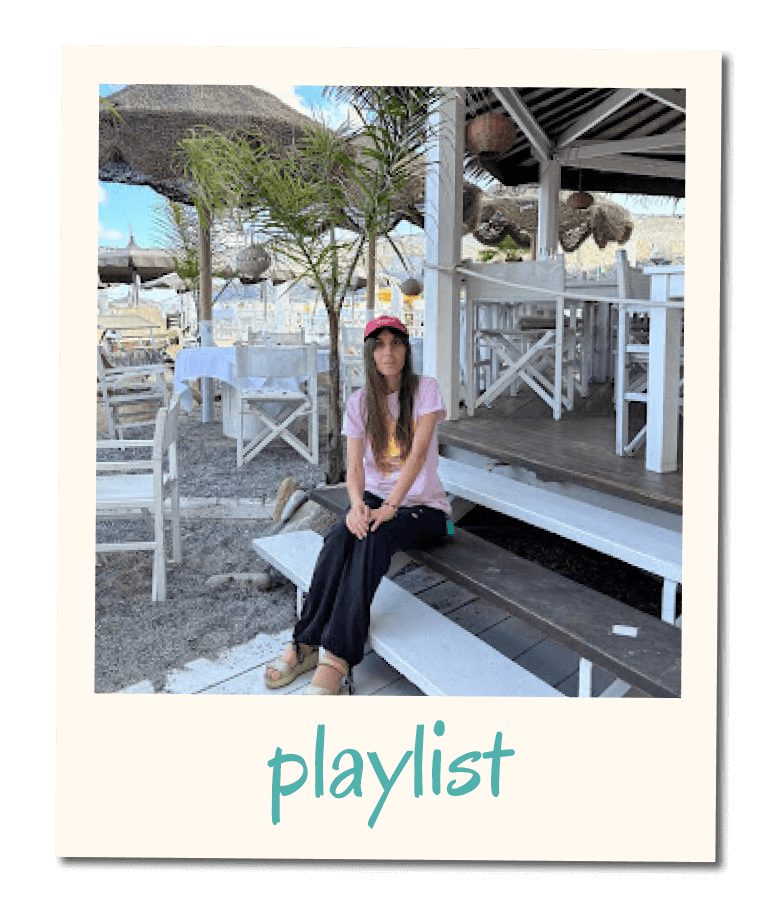 Card di una playlist con fotografia in stile polaroid di Flavia seduta all’aperto in un ambiente sul mare, con la scritta ‘playlist’ nella cornice inferiore.